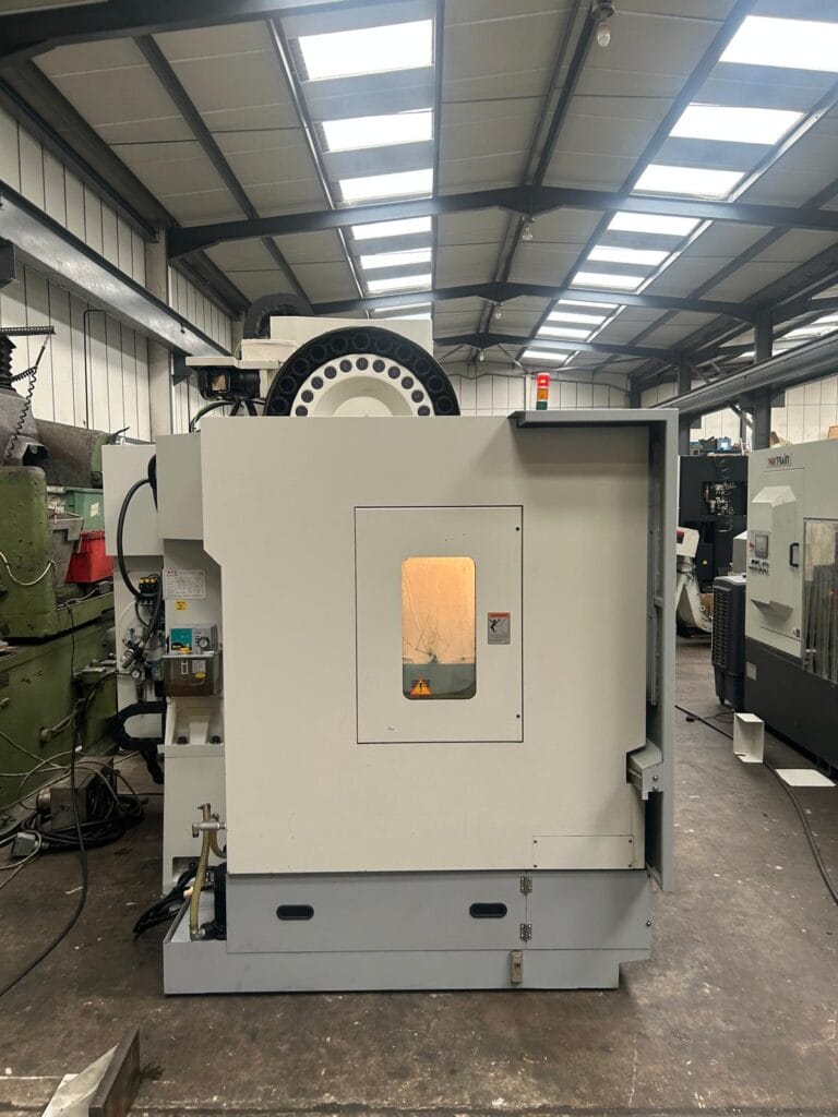 Rear view of an XYZ 710 VMC CNC machining centre with tool carousel and inspection window